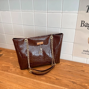 Glossy dark brown crocodile embossed tote bag with gold chain strap and reindeer pendant