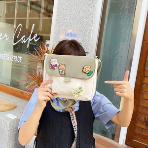 Sac à bandoulière minimaliste en toile beige et vert olive avec broches de dessins animés