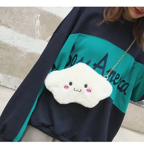 Close-up of white plush cloud-shaped crossbody bag with cartoon smiley face and gold chain