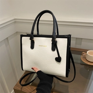 Contrast stitching tote bag with bow relief and heart charm for stylish urban commuting