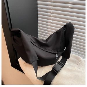 Detailed macro of a black crescent nylon crossbody bag featuring a sturdy front zipper