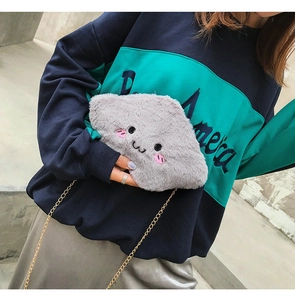 Detail view of cute gray plush cloud bag featuring sweet facial embroidery and gold chain