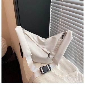 Detailed macro of a cream-white nylon crossbody bag with zipper and plastic buckle strap