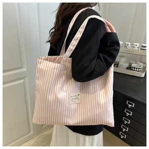 Close-up of pink and white striped canvas tote bag with decorative fabric patch