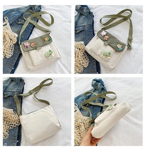 Détails du petit sac bandoulière en toile avec rabat vert olive et broches d'animaux