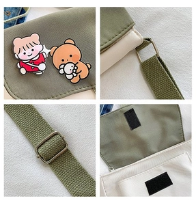Détail de sac bandoulière en toile avec sangle ajustable et badges de dessin animé