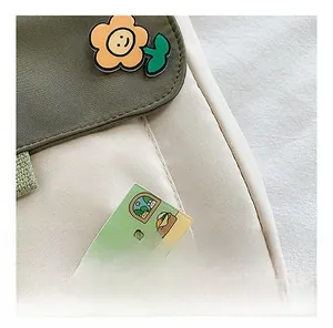 Détail du sac en toile vert et beige avec badge fleur et illustration mignonne