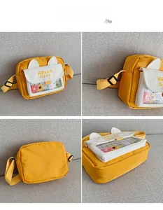 Detail showing the transparent front pocket with colorful plush flowers on the yellow bag