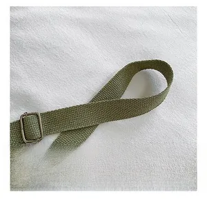 Gros plan détaillé de la bandoulière en toile vert armée avec boucle en métal argenté