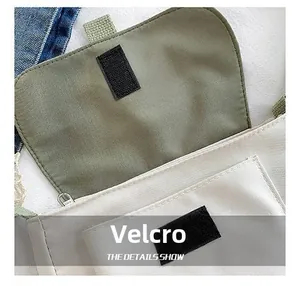 Vue détaillée du velcro et de la poche avant sur le sac à bandoulière en toile crème