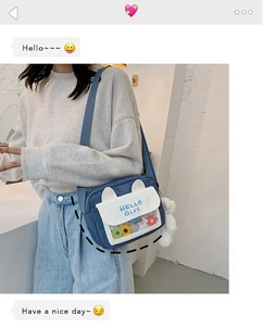 Blue canvas crossbody bag with white cat ear flap and colorful knit flower details