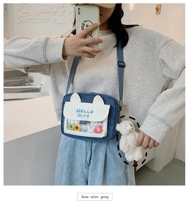 Mirror selfie showing the blue canvas crossbody bag with cat ears and plush bear charm
