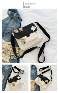 Détail du sac à bandoulière en toile avec badges de dessin animé et sangle réglable