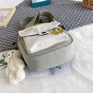 Detail view of mini green canvas bag with cartoon car badge and cute plush puppy charm