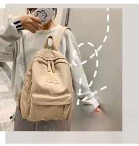 Side view of a beige Korean style backpack featuring a large front pocket and padded straps