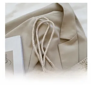 Détail des poignées en corde et texture tissée du sac à bandoulière en paille