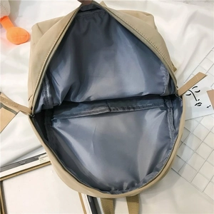 Top view showing the spacious main compartment and inner pocket of the beige backpack