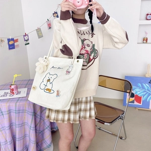 Détail d'un sac cabas en velours côtelé blanc avec motifs ours et porte-clés ours peluche
