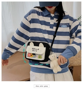 Detail of cute canvas crossbody bag with HELLO Girl print and plush bear pendant