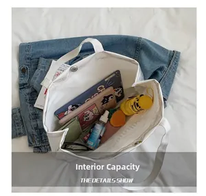 Détail montrant la capacité interne du sac cabas en toile blanche avec fermoir aimanté