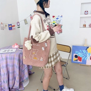 Détail d'un sac cabas en velours côtelé rose avec imprimé ours et breloque peluche
