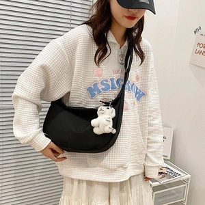 Women's black nylon crescent moon bag with wide strap and cute plush charm pendant