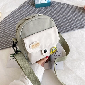 Detail showing the mini canvas crossbody bag with Bread Comcom print and car badge