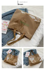 Détail du sac cabas en PVC marron avec logo vert et boucle de fermeture magnétique en métal