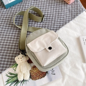 Detail of olive green nylon mini crossbody bag with cute white panda plush pendant
