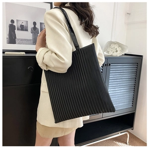 Detail view of the black pleated tote bag showing the textured high-density fabric finish