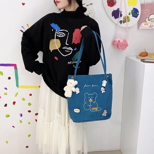Détail du sac cabas en velours côtelé bleu avec broderie d'ours et épingles déco