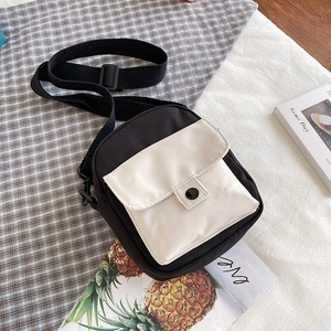 Close-up of black and white canvas crossbody bag with adjustable wide fabric strap