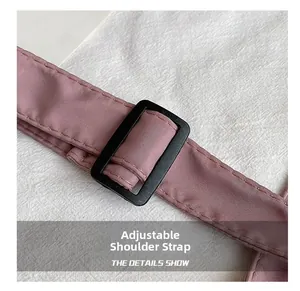 Detail of pink nylon shoulder strap with adjustable black plastic buckle and stitch texture