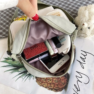 Internal view showing a mini green nylon canvas bag with spacious room for cosmetics and phone