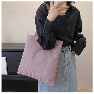 Detail view of pink pleated tote bag showing unique vertical pleat texture and soft fabric