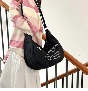 Detail shot of the black canvas tote bag with adjustable strap and side pockets