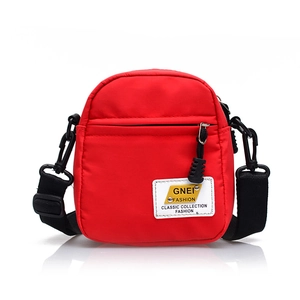 Piccola borsa a tracolla in nylon rosso con tracolla regolabile ed etichetta bianca