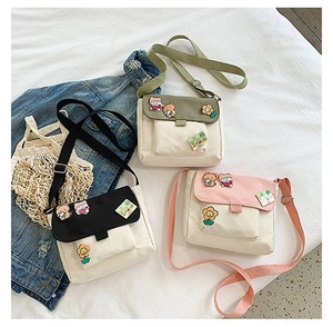 Trois sacs bandoulière mignons en toile de couleur noir, vert et rose avec patchs cartoon