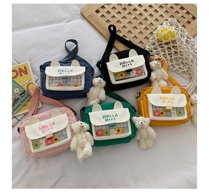 Detailed flat lay of cute canvas crossbody bags in five colors with plush bear charms