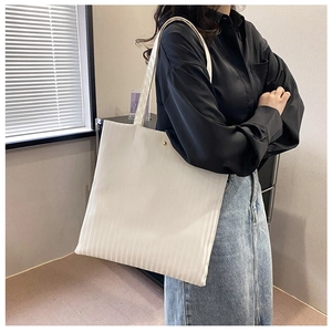 Detailed shot of white vertical striped corduroy tote bag showing textured fabric