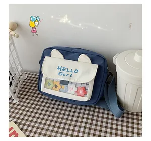 Detail view of navy canvas bag with cat ears and small colorful woven flowers inside PVC window