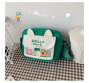 Close-up of green canvas crossbody bag with cat ears and floral clear window detail