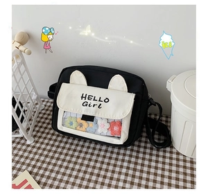 Close-up of cute black and white canvas bag with cat ears and rainbow plush flowers