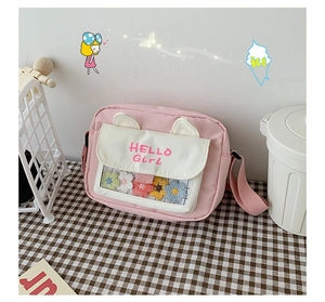 Detailed view of pink crossbody bag with colorful plush flowers inside a clear window