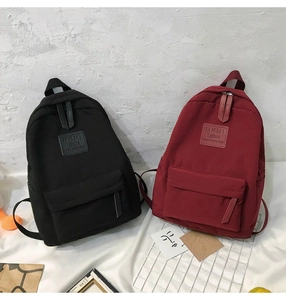Detail view of black and dark red nylon backpacks featuring MRMI Leisure logo labels