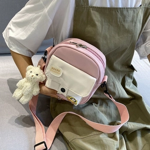 Detail of pink nylon mini crossbody bag with bread patch and plush bear charm