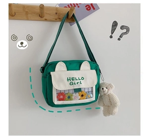 Detail of green canvas crossbody bag featuring a clear window filled with plush flowers