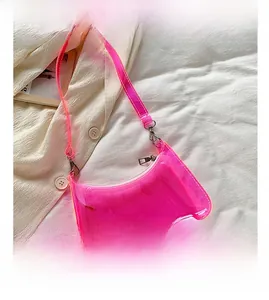 Top view of bright pink transparent PVC jelly bag on a beige jacket and white background