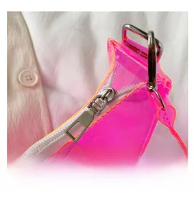 Close-up of a pink transparent PVC bag showing smooth white zipper and silver metal slider