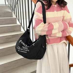Minimalist black canvas crescent tote bag with adjustable strap for daily commute